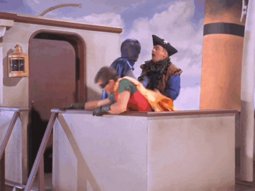 a man in a pirate costume is talking to a man in a blue suit