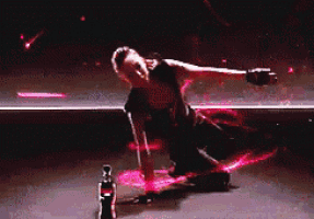a man is kneeling on a stage with a bottle of coca cola in front of him