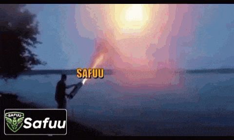 a man is holding a flamethrower in front of a large sun .