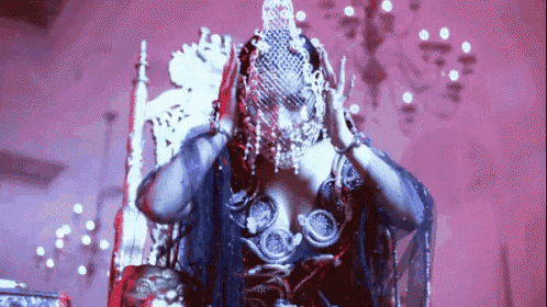 a woman is sitting on a throne with a veil on her head .