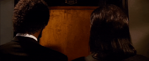 a man and a woman are standing in front of a door .