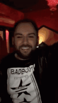 a man with a beard wearing a badboy t-shirt