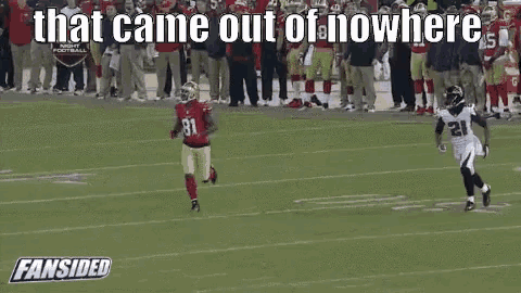 a football player running on a field with the words that came out of nowhere behind him .