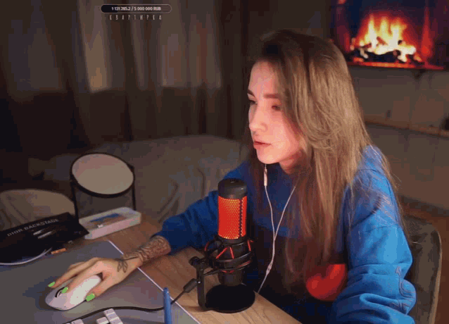 a woman sitting at a desk with a microphone and a sign that says ' a ' in the corner