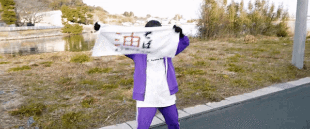 a person in a purple jacket is holding a white banner that says ' freedom ' on it