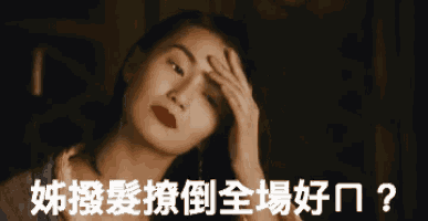 a woman holds her hand to her forehead in a dark room