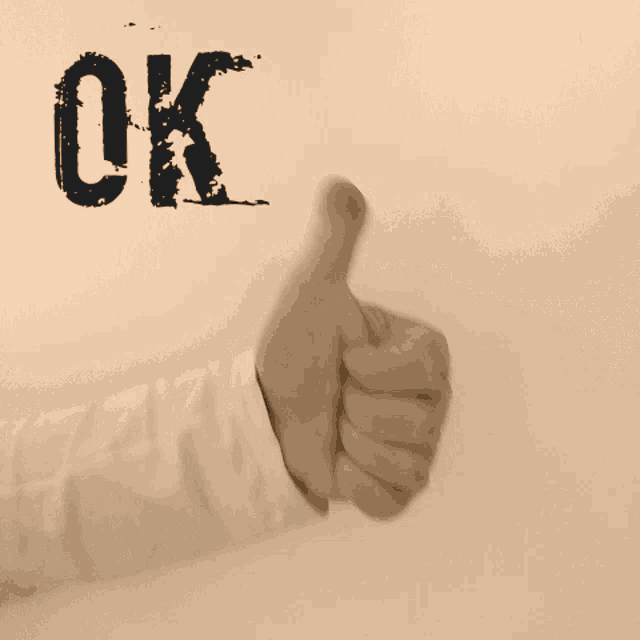 a person 's fist is against a wall with the word ok on it