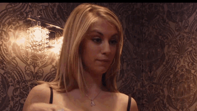 a woman wearing a bra and a necklace with a letter a on it