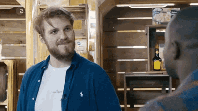 a man wearing a polo shirt that says stone island talks to another man