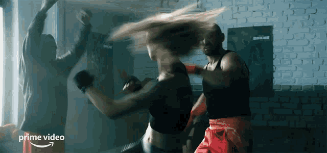 a man and a woman are boxing in a room with a prime video logo