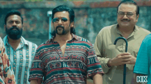 a group of men are standing next to each other and one of them is wearing sunglasses .