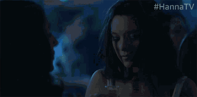 a woman is dancing in a dark room with #hannatv written on the bottom of the screen