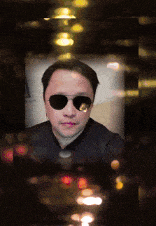 a man wearing sunglasses looks at the camera
