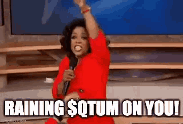 a woman in a red dress is holding a microphone and saying `` raining sqtum on you ! ''