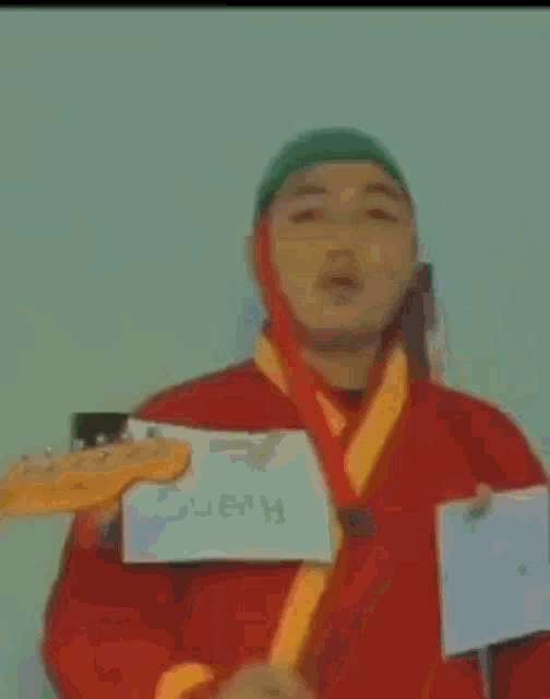 a man wearing a green hat and a red shirt is looking at something .