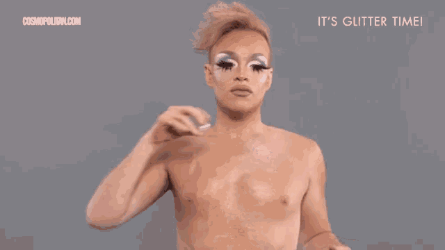 a man without a shirt is applying glitter to his face in front of a cosmopolitan.com ad