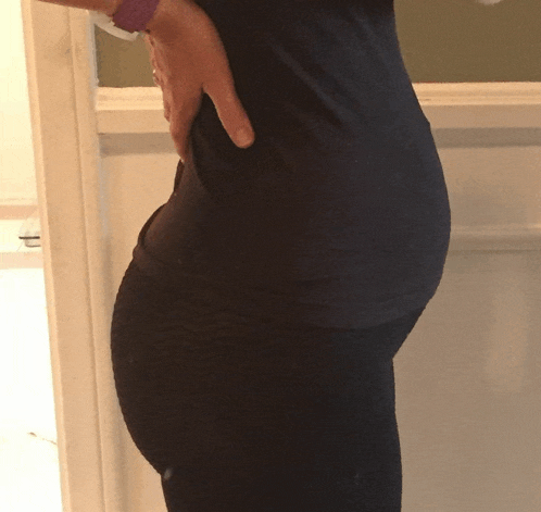 a woman in a black shirt holds her hand on her waist