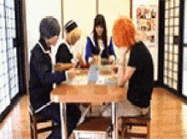 a group of people are sitting around a table eating food .