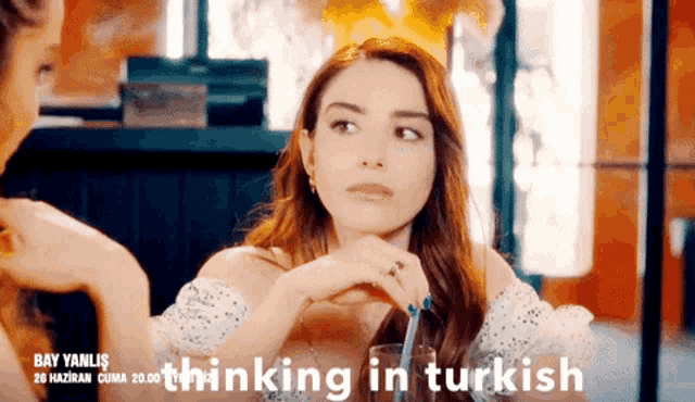 a woman sitting at a table with the words thinking in turkish written above her
