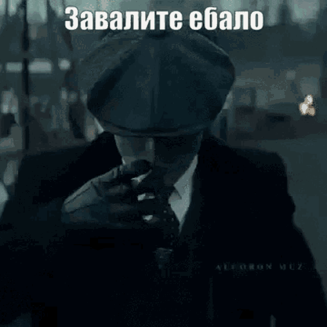a man in a suit and tie is smoking a cigarette in a meme .