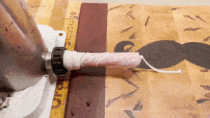 a sausage maker is being used to make a sausage on a wooden cutting board