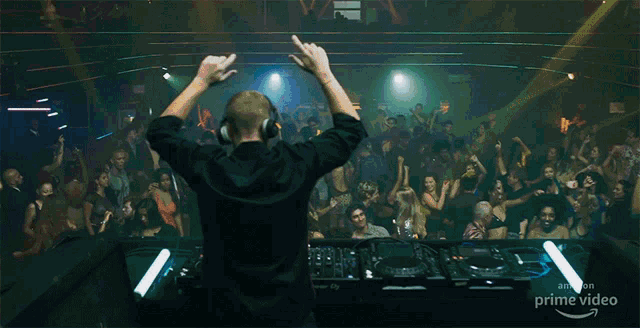 a man wearing headphones is giving the middle finger in front of a crowd of people at a party sponsored by amazon prime video