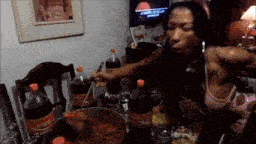 a woman is sitting at a table with many bottles of coca cola