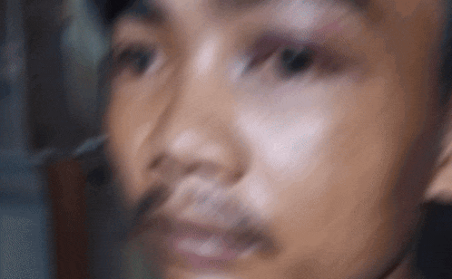 a blurry picture of a man 's face with a beard .