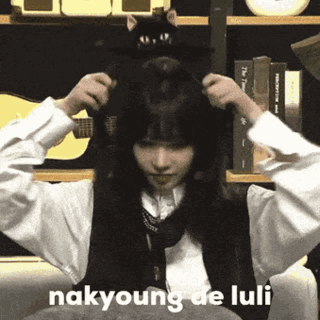 a woman wearing a black cat hat with the words nakyoung de luli written on the bottom