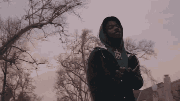 a young man wearing a green hoodie with the letter r on it