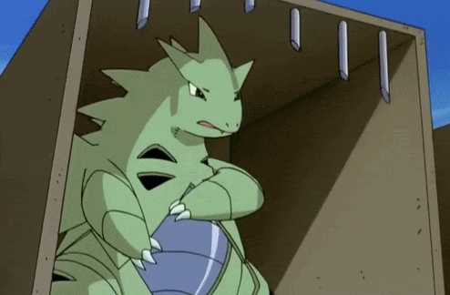 a green cartoon dragon is sitting in a cardboard box .