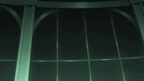 a green light is shining through a dark window