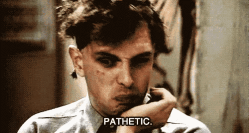 a man is talking on a cell phone and the word pathetic is written below him