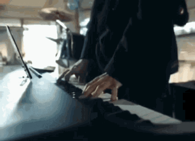 a person is playing a keyboard with their hands