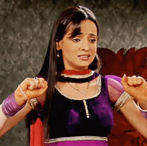 a woman in a purple and black dress holds her fist up