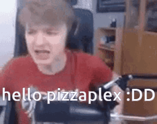 a man in a red shirt is sitting in a chair and saying hello pizzaplex : dd