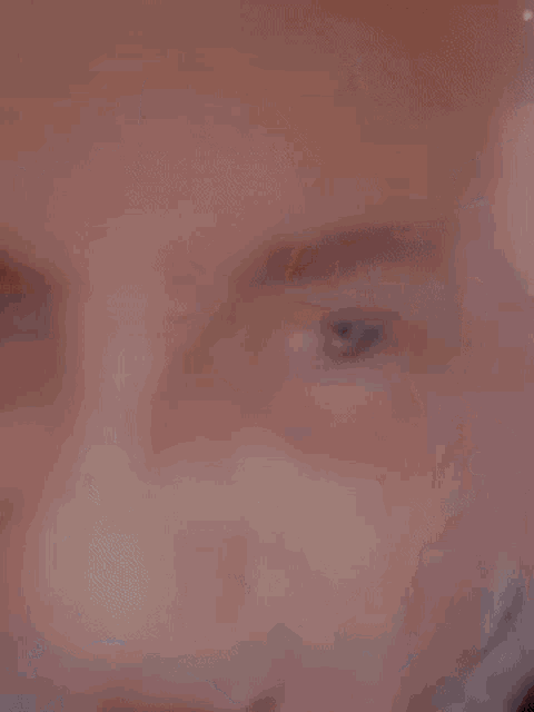 a close up of a man 's face with his mouth open and a surprised look on his face .
