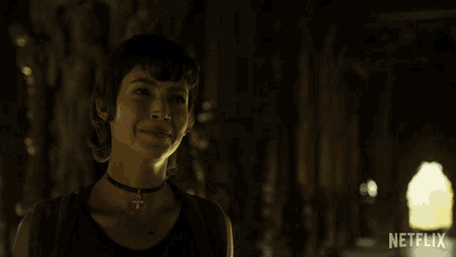 a woman is smiling in a dark room with a netflix logo on the bottom