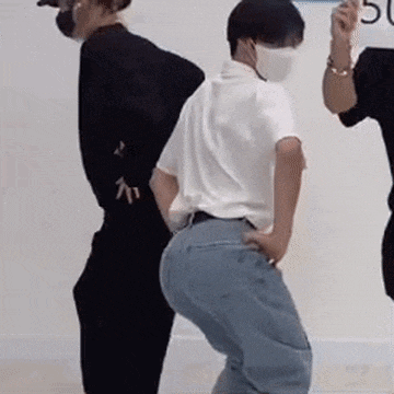 a man wearing a mask is dancing with two other men in a dance studio .