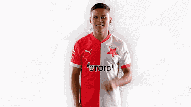 a man wearing a red and white jersey with the word etoro on the front