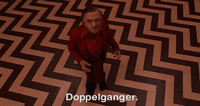 a man in a red suit is standing in a room with a chevron patterned floor .