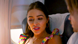 a woman is sitting on a plane with her eyes closed and a man is looking at her .