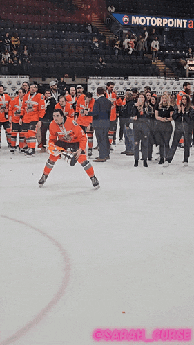 a group of hockey players on the ice in front of a motorpoint sign