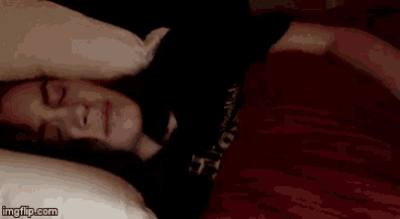 a close up of a person 's face with a red blanket .