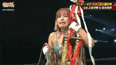 a female wrestler is crying while holding a trophy
