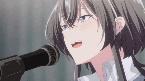 a girl is singing into a microphone with her mouth open