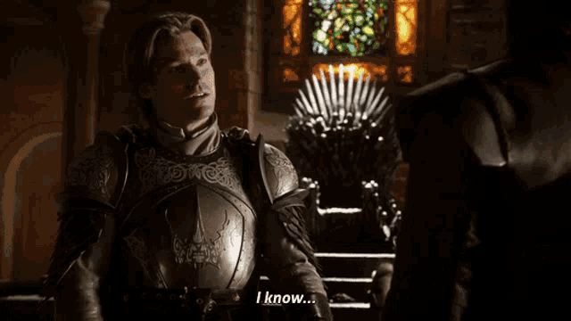 a man in armor says " i know " in front of a stained glass window