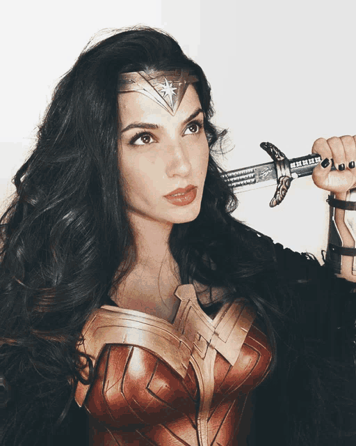 a woman dressed as wonder woman holds a sword