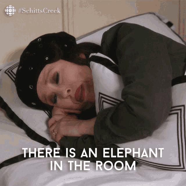 a woman laying on a bed with the words there is an elephant in the room below her