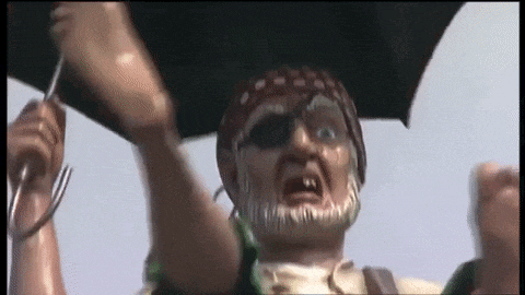a statue of a pirate is holding an umbrella in his hand .